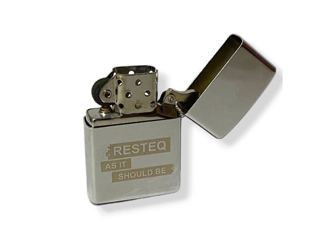 Классическая бензиновая зажигалка типа Зиппо с надписью 'RESTEQ AS IT SHOULD BE'. Многоразовая зажигалка - Фото NaN