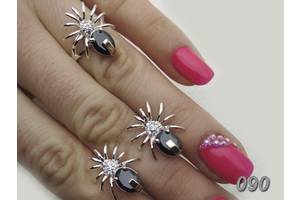Комплект женских украшений - кольцо и серьги в виде паучков из серебра с фианитами и золотыми пластинами.